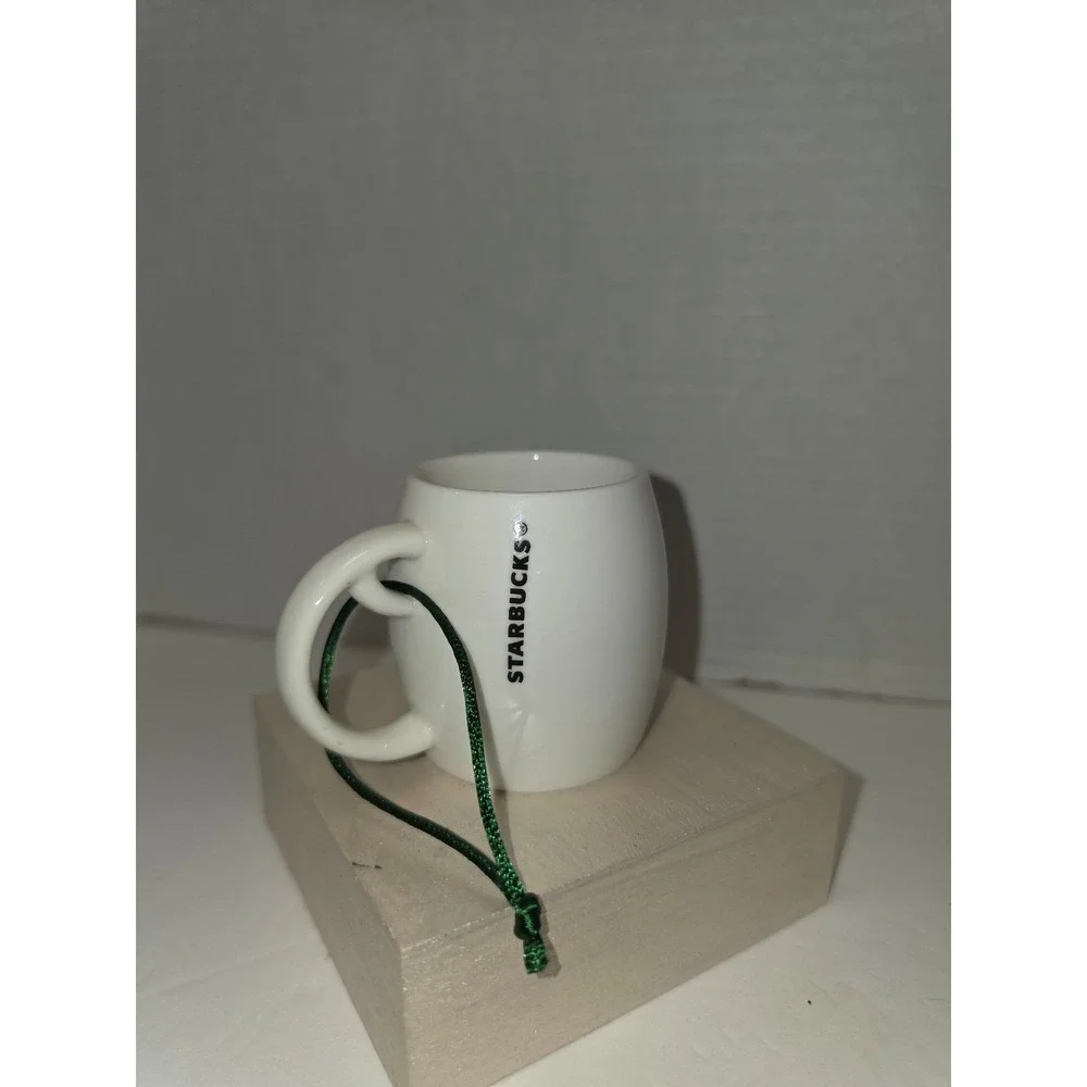 white‎ ceramic Starbucks ornament featuring a green siren logo
